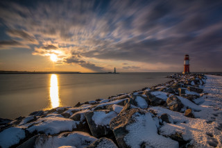 Lighthouse rocky shore sunset snow - radiant free wallpaper