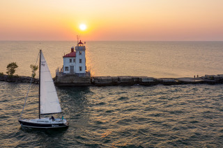 Sailboat lighthouse sunset ocean beach - a sailboat free wallpaper