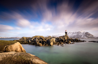 Lighthouse rocky shore mountain cloudy - a mountain in the background free wallpaper