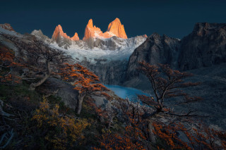 Mountain lake trees snow capped - the foreground and a snow free wallpaper