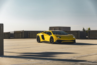 Yellow sports car parking lot 35 - a sky background and a building in the background free wallpaper