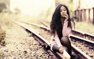 Woman sitting train track smiling - a train track free wallpaper