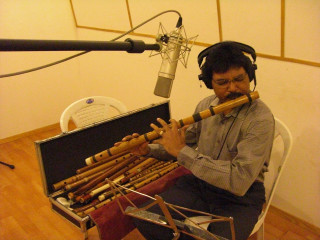 Man sitting chair playing recorder - headphone free wallpaper