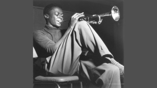 Man sitting chair playing trumpet - studio portrait free wallpaper