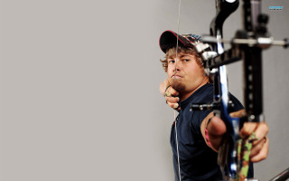 Man holding bow aiming gun - his head free wallpaper