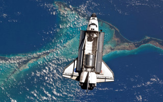 Space shuttle flying over ocean - a space shuttle free wallpaper