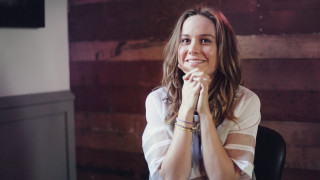 Woman smiling table hands folded - studio portrait free wallpaper