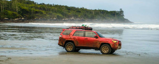 Red suv parked beach water - dan scott free wallpaper