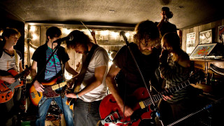 Young men playing guitars room - a group free wallpaper