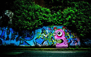 Graffiti covered face bush green 2 - a green bush free wallpaper