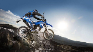 Man riding dirt bike mountain - action free wallpaper