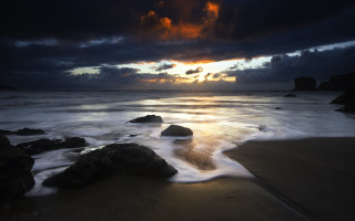 Sunset ocean rocks dark sky - a dark sky in the background free wallpaper