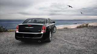 Black car gravel road ocean 2 - a black car free wallpaper