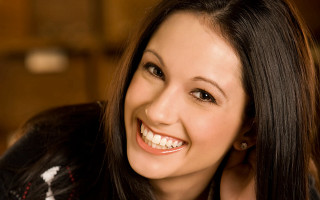 Woman smiling longhair blackjacket whiteflower - facial feature free wallpaper