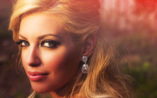 Woman blonde hair earrings red - a red light behind her free wallpaper