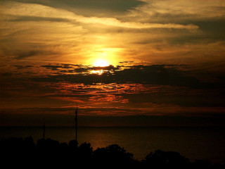Sunset clouds trees water background - the foreground and a body of water free wallpaper