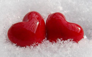 Two red hearts sitting in - snow free wallpaper