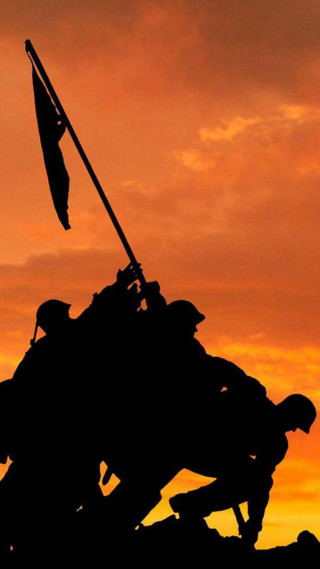 Soldier silhouette holding flag sunset - a statue free wallpaper for mobile