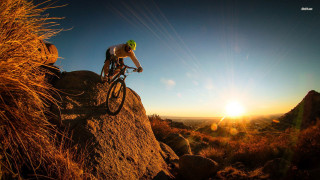 Man riding bike rocky hillside - a rocky hillside free wallpaper