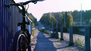 Bike parked fence roadside trees - a bike free wallpaper