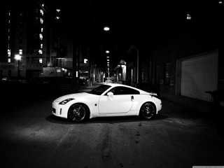 White sports car dark street - night time in a city free wallpaper