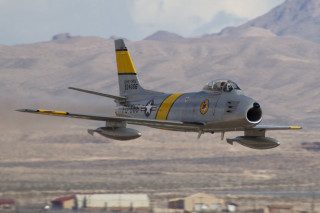 Fighter jet flying mountains skyline - the background and a sky line in the foreground free wallpaper