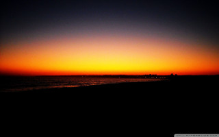Sunset ocean boat person walking - the beach in the foreground free wallpaper