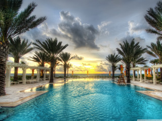 Sunset pool palm trees clouds - a large swimming pool free wallpaper