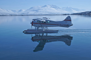 Small plane floating water mountain - a boat in the foreground free wallpaper
