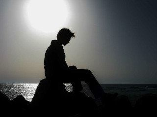 Man sitting rock ocean sunshine - near free wallpaper for desktop