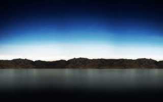 Large body water mountains skyline - the background and a sky line in the foreground free wallpaper