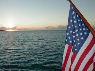 Flag boat water sunset distant - a boat in the distance free wallpaper
