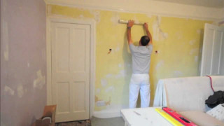 Man painting yellow room white - a white door free wallpaper