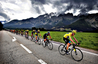 Cyclists riding road mountain range - great composition free wallpaper