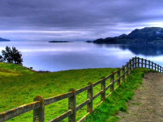 Wooden fence grassy hill lake - a grassy hill free wallpaper