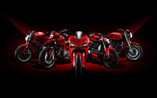 Motorcycles lined up black background - a red light behind them free wallpaper