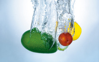 Fruit dropping into glass of - a lime free wallpaper