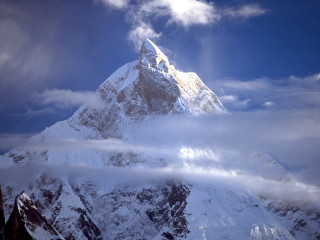 Snowy mountain cloudy sky sunbeam 2 - a sunbeam in the distance free wallpaper