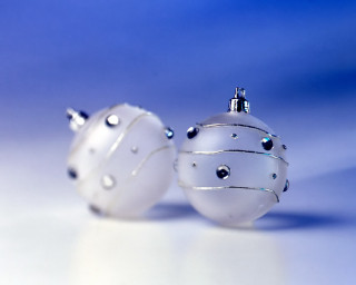 Two white ornaments sitting on 2 - shiny free wallpaper