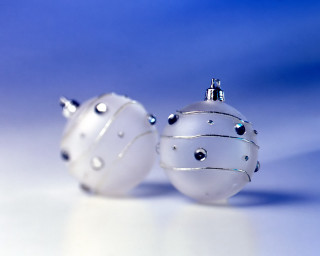 Two white ornaments sitting on 3 - shiny free wallpaper
