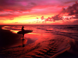 Person holding surfboard beach sunset - the sky above them free wallpaper