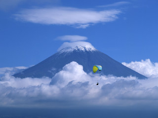 Mountain kite flying sky clouds 4 - a surfboard in the foreground free wallpaper