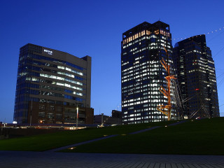 Grassy area tall buildings nighttime - a grassy area in front free wallpaper