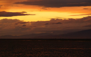 Sunset boat water mountains clouds - alan sutherland free wallpaper