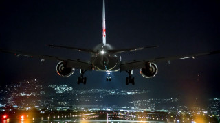 Jetliner night city lights flying - over a city free wallpaper