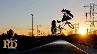 Man riding bike ramp sunset - power free wallpaper