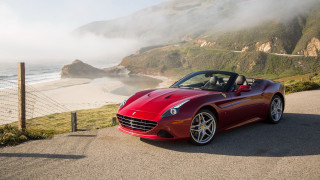 Red sports car ocean cliff - a beach in the background free wallpaper