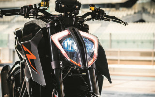 Motorcycle closeup headlight building background - a close up of a motorcycle free wallpaper